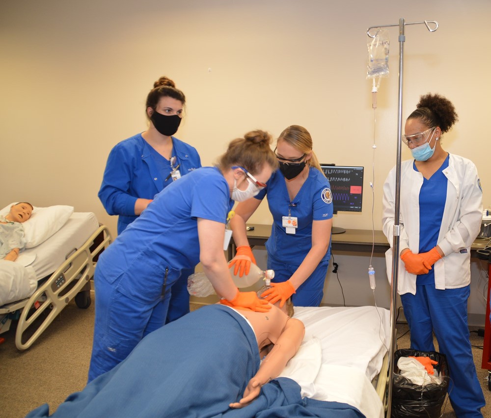 Nursing students practicing on a training dummy